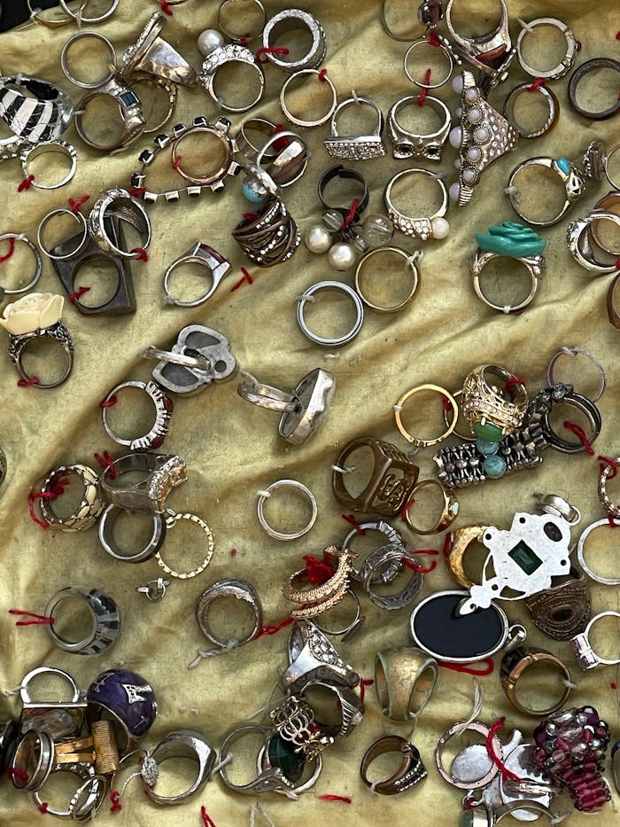 Assorted rings of various designs and materials on a golden background.